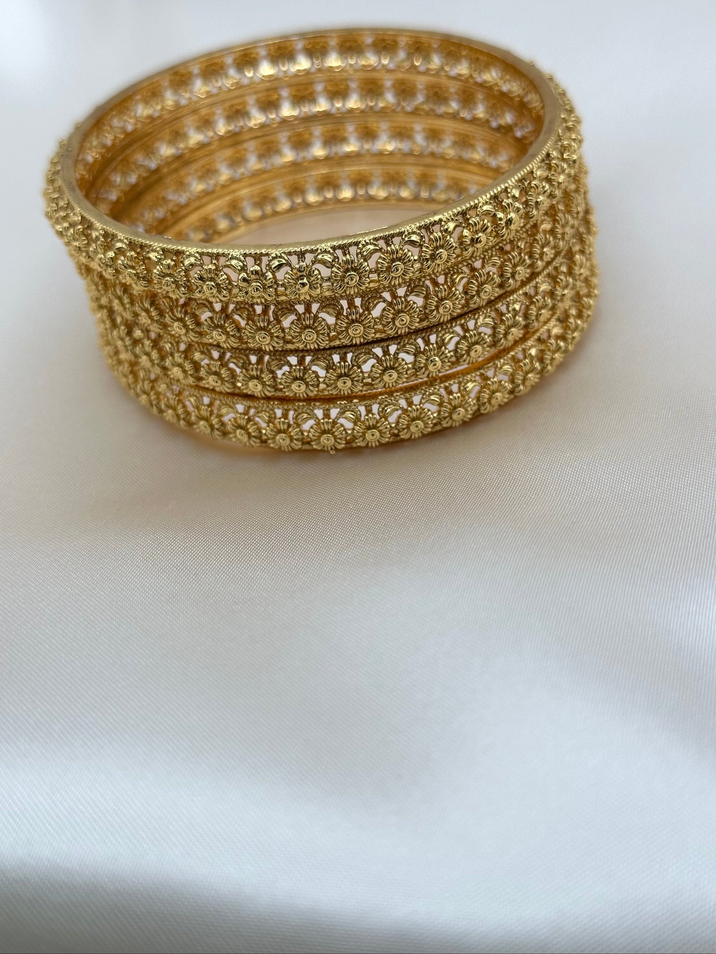 Stack of gold bangles on a white background