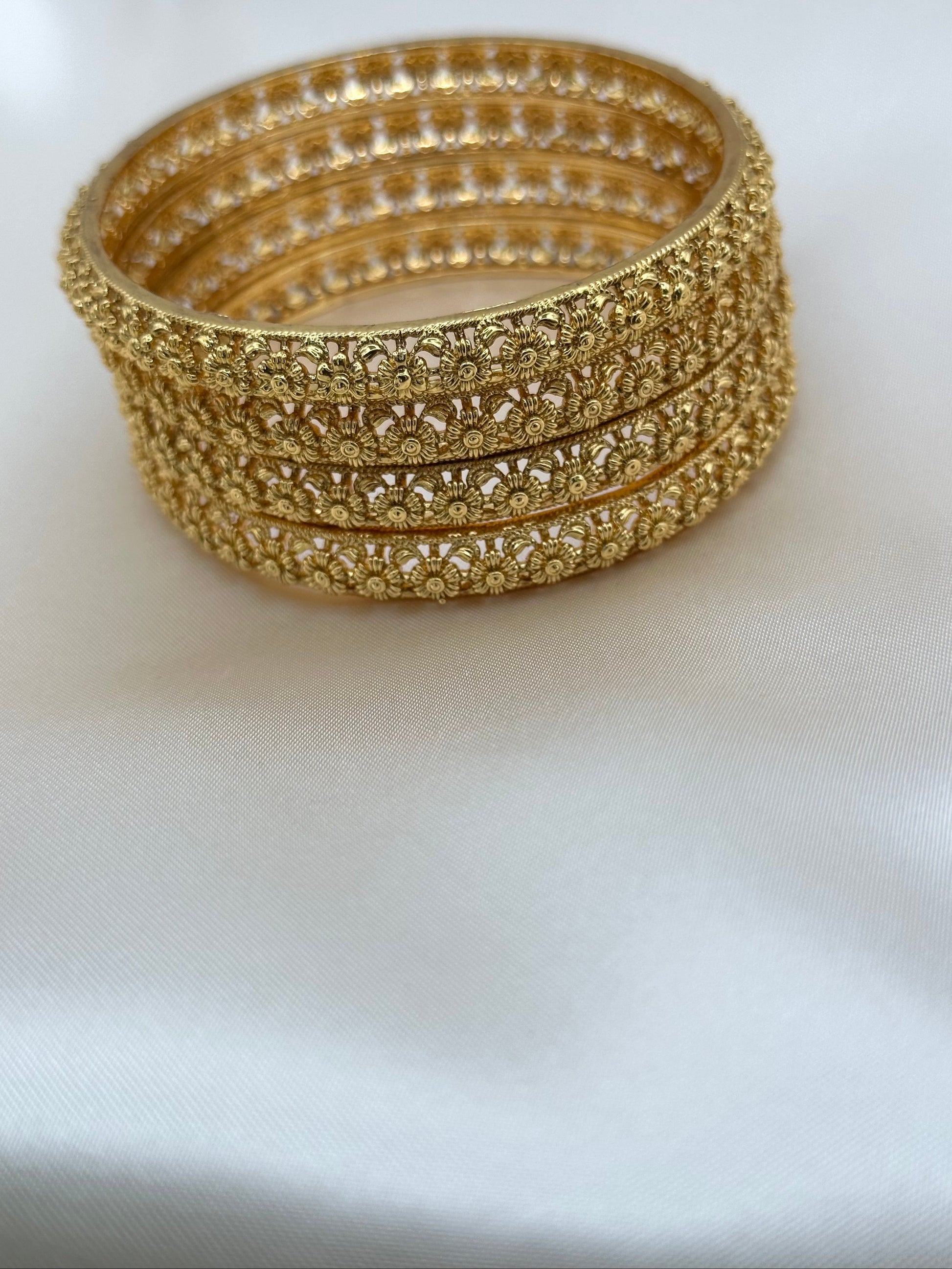 Stack of gold bangles on a white background