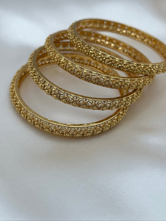 Set of gold bangles on a white background